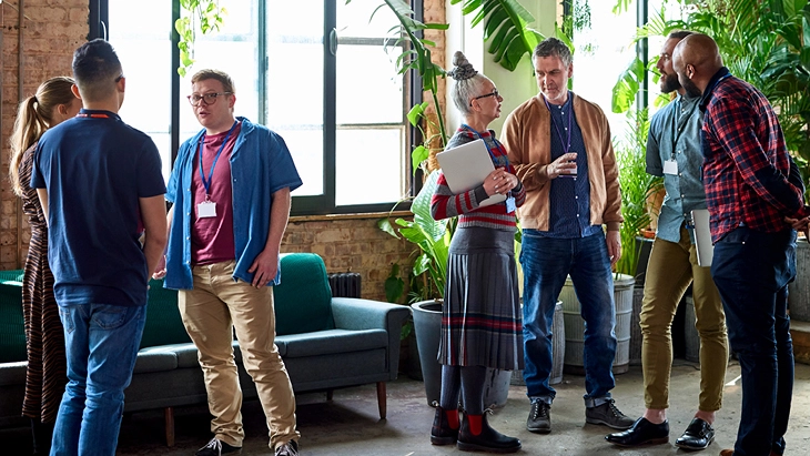 A diverse group of people talking at work in office